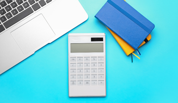 Calculator and laptop on a blue desk